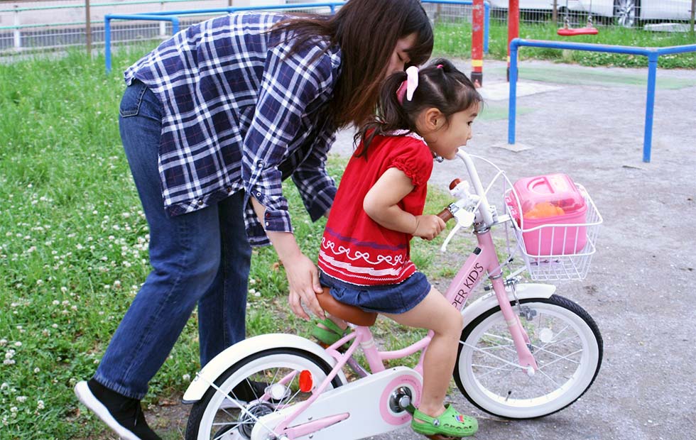 自転車の練習をする親子